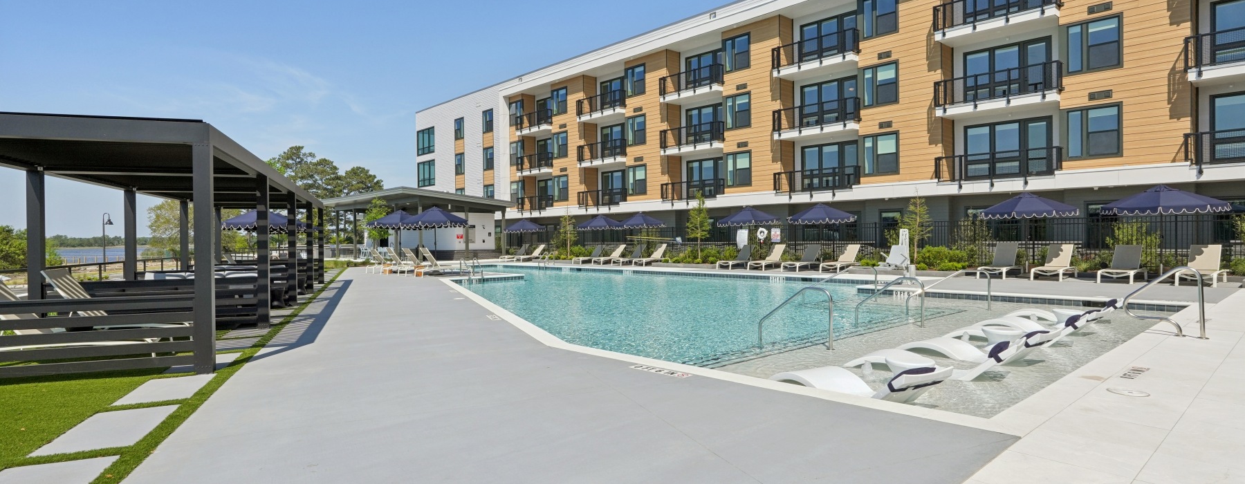 a swimming pool next to a building overlooking the water