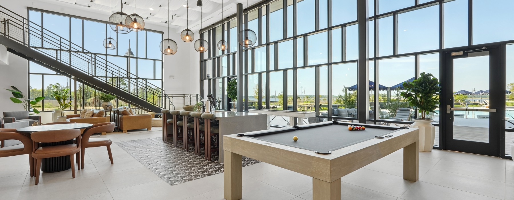 open community room with billards and expansive windows
